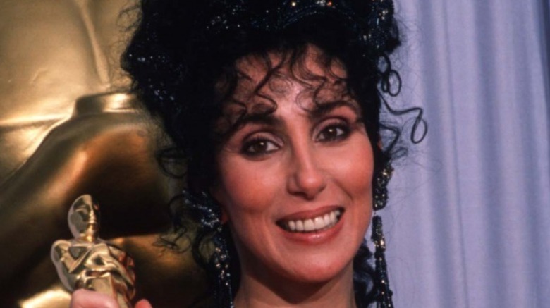 Cher holds her Best Actress in a Leading Role Oscar for "Moonstruck" at the Academy Awards April 11, 1988 