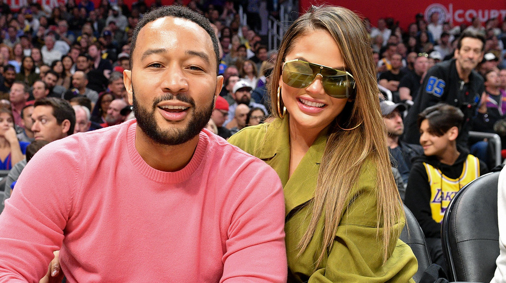 John Legend and Chrissy Teigen at a basketball game