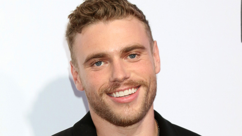 Gus Kenworthy on red carpet, smiling