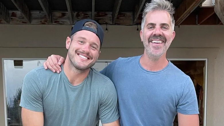 Colton Underwood and Jordan C. Brown, smiling in front of house