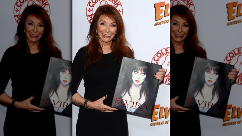 Cassandra Peterson holds Elvira book