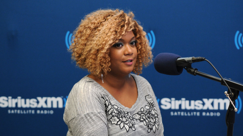 Sunny Anderson speaks into a microphone.