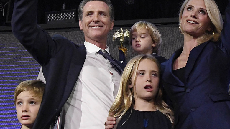 Gavin Newsom Jennifer Siebel smiling waving with their children