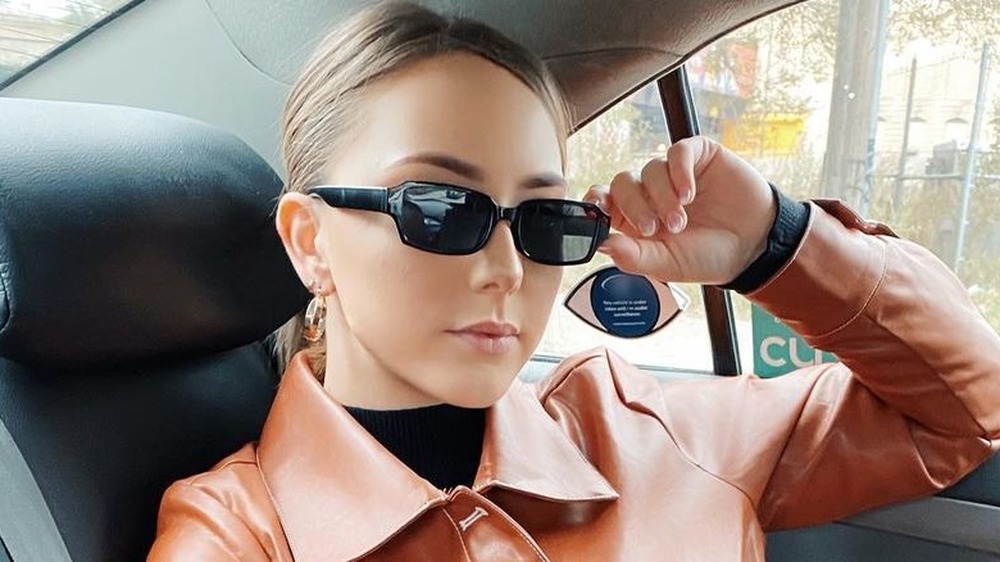 Hailie Mathers in backseat of car, sunglasses on