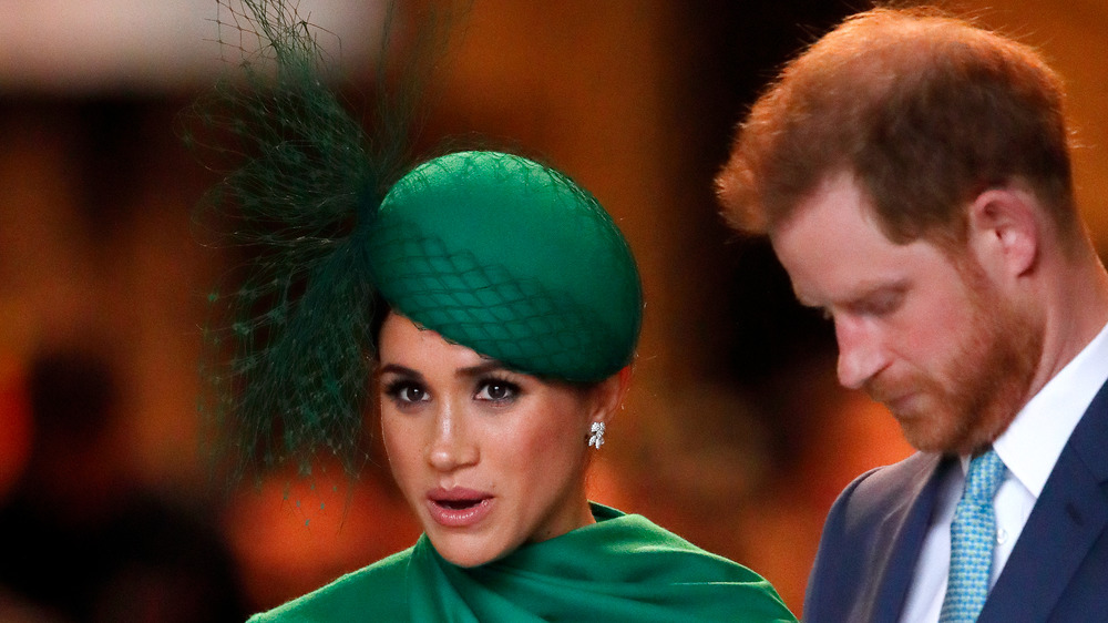 Meghan Markle speaking, Prince Harry looking down