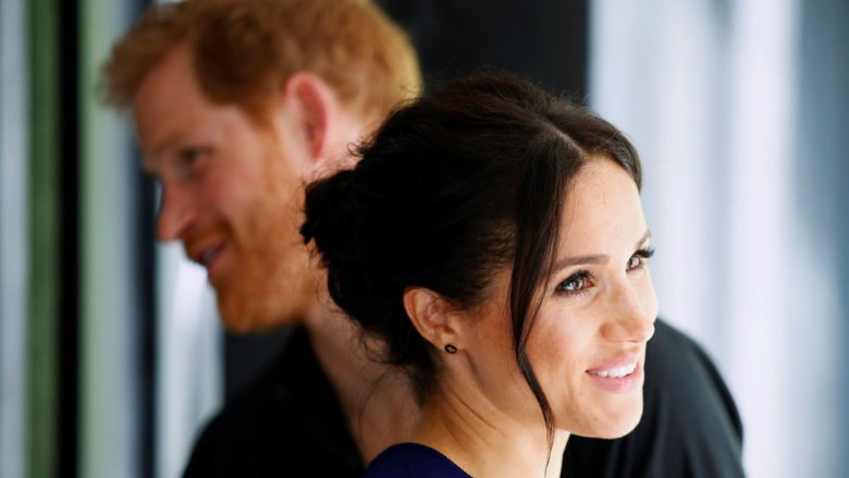 Prince Harry and Meghan Markle looking in opposite directions