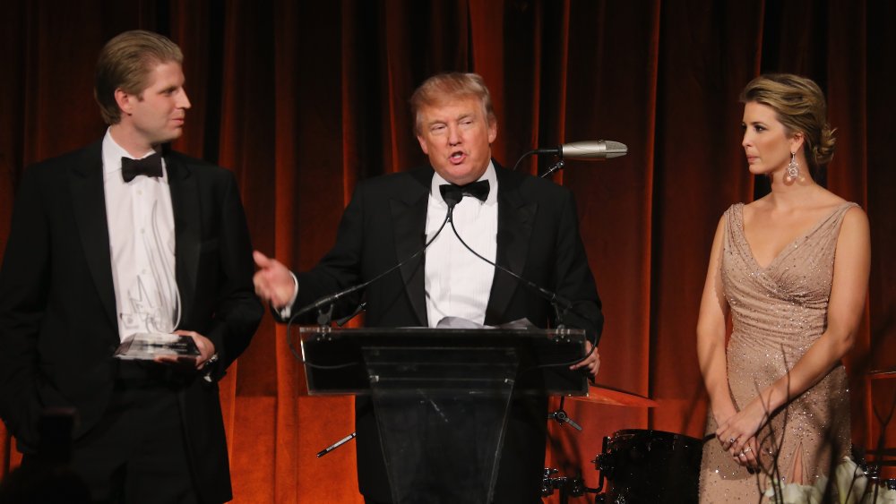 Eric Trump, Donald Trump and Ivanka Trump standing at a podium