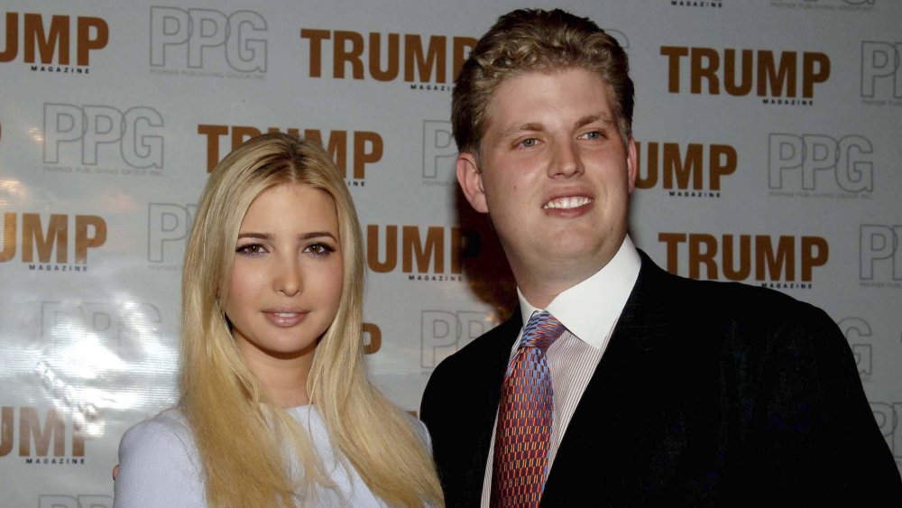 Ivanka Trump and Eric Trump in front of a Trump promo wall