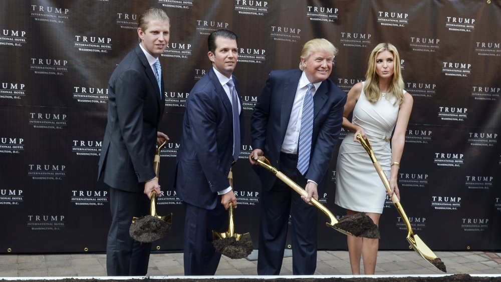 Eric Trump, Donald Trump Jr., Donald Trump, and Ivanka Trump all holding gold shovels with dirt