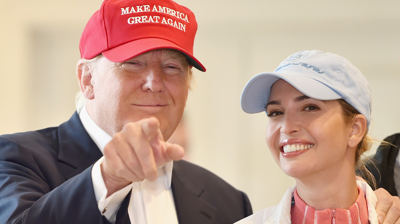 Donald Trump and Ivanka Trump, both dressed casually, wearing hats, and smiling