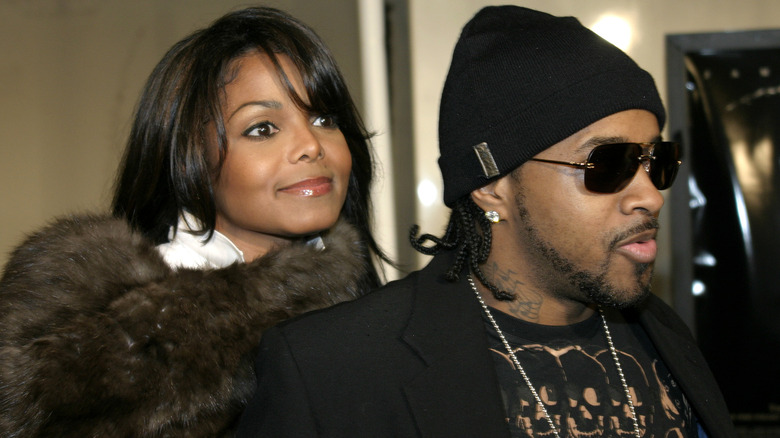 Janet Jackson smiling behind Jermaine Dupri