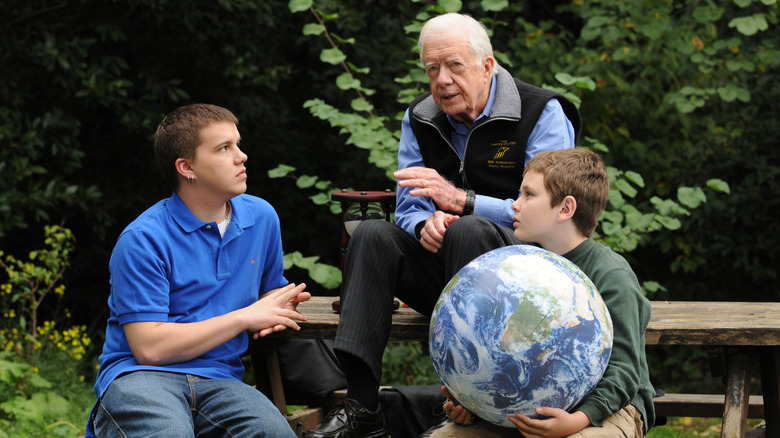 Jimmy Carter, grandsons Jeremy and Hugo seated at picnic table