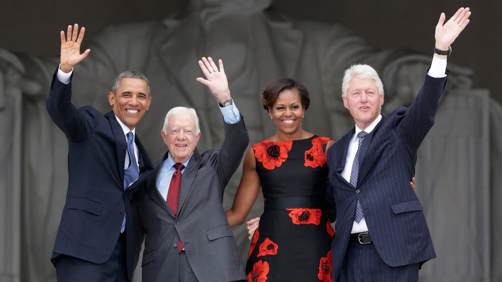 Barack Obama, Jimmy Carter, Michelle Obama, and Bill Clinton waving at the Lincoln Memorial