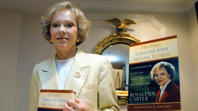 Rosalynn Carter holding a copy of her book "Helping Someone with Mental Illness"