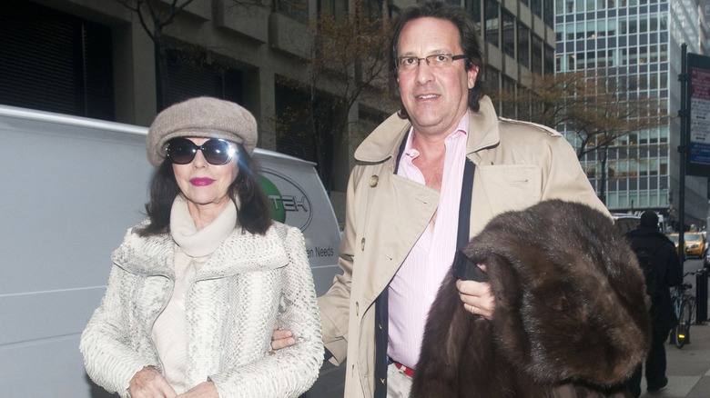 Joan Collins and Percy Gibson walking together