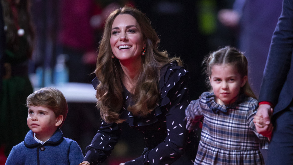 Kate Middleton holding Prince Louis and Princess Charlotte's hands