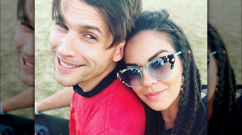 Katie Maloney resting her head on Tom Schwartz' back, both smiling