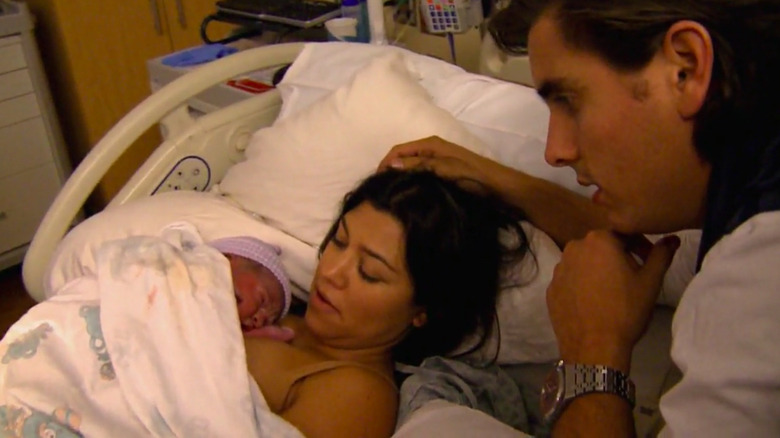Kourtney Kardashian holding newborn with Scott Disick
