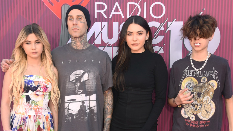 Travis Barker with his kids on a red carpet
