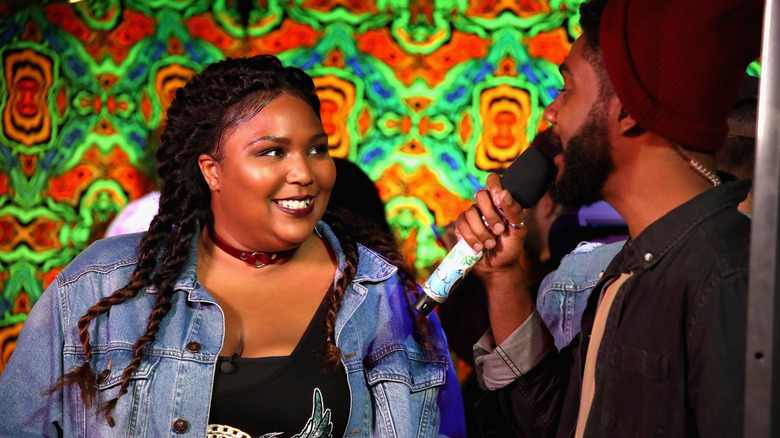 Lizzo smiling at Myke Wright while hosting Wonderland