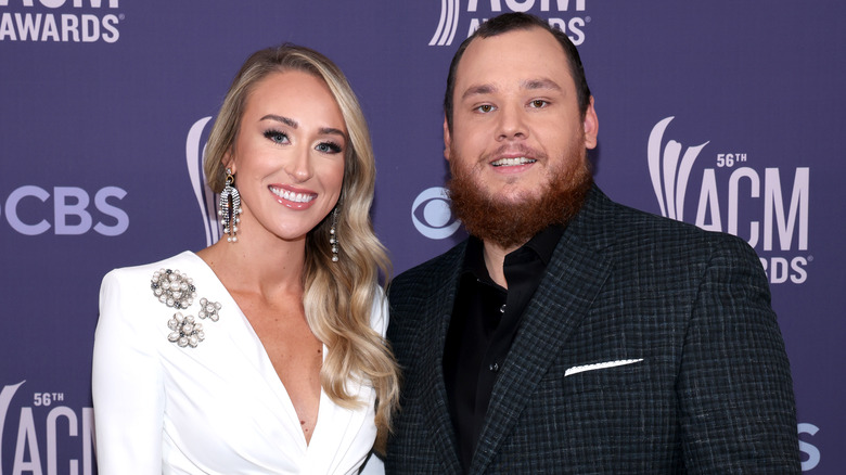 Nicole Hocking Combs, smiling, wearing a white dress, Luke Combs, wearing a suit, smiling, 2021 photo