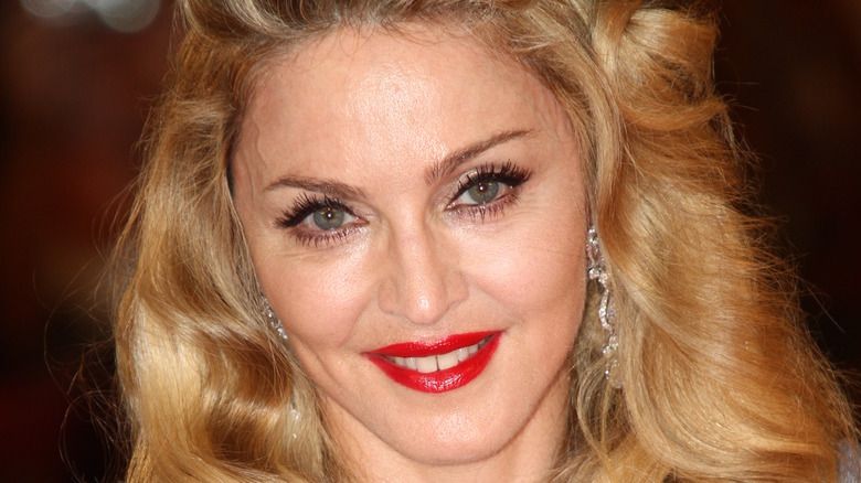 Madonna smiles wearing red lipstick