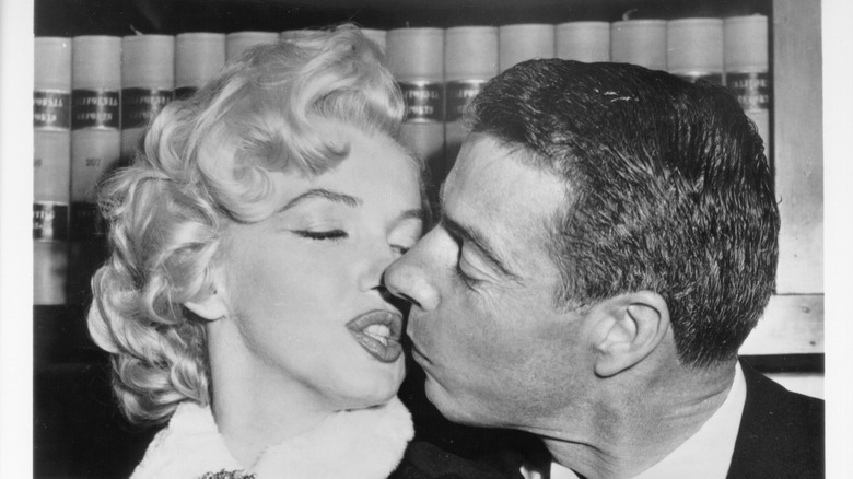 Marilyn Monroe and Joe DiMaggio kissing