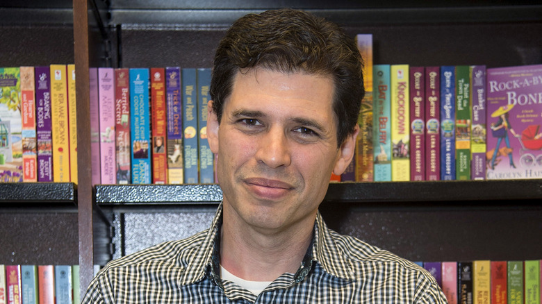 Max Brooks in front of bookshelf