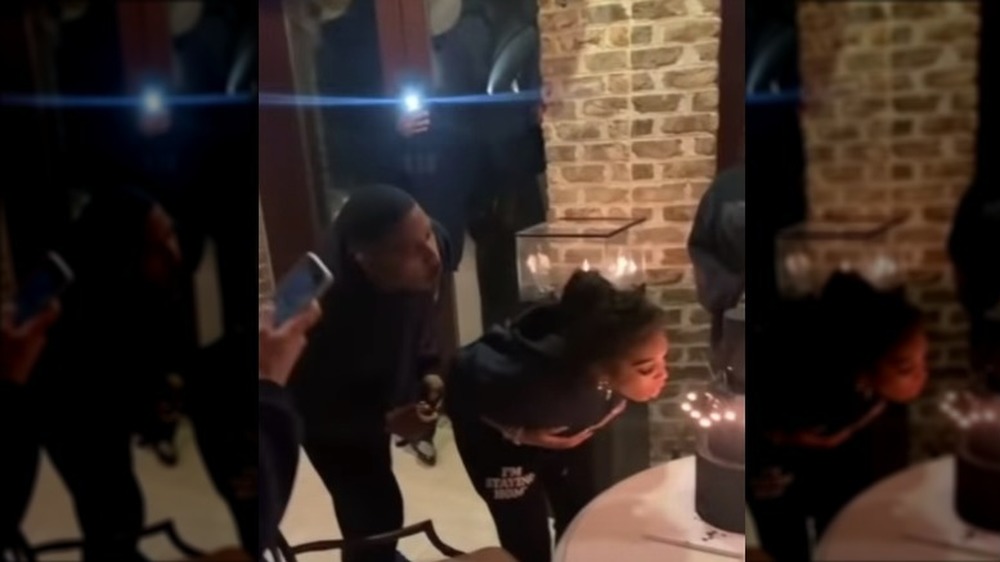 Michael B. Jordan and Lori Harvey blowing out the candles on her birthday cake