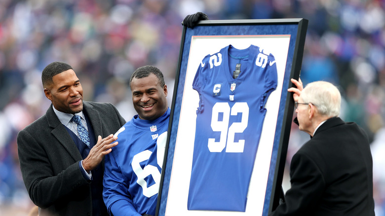 Michael Strahan gazing at his retired jersey