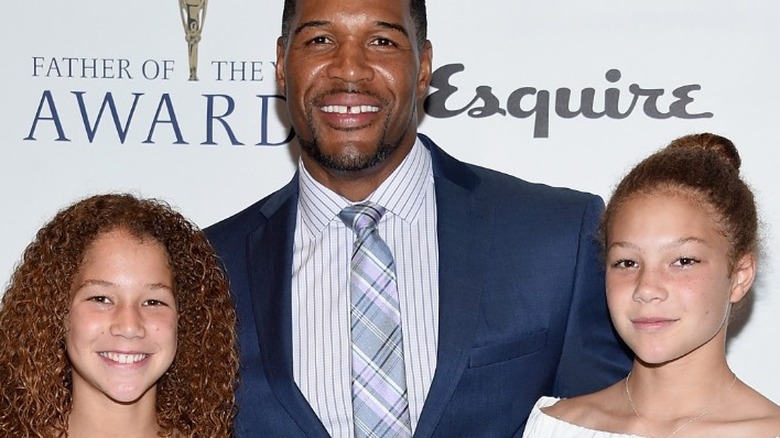 Michael Strahan and his twin daughters, all smiling