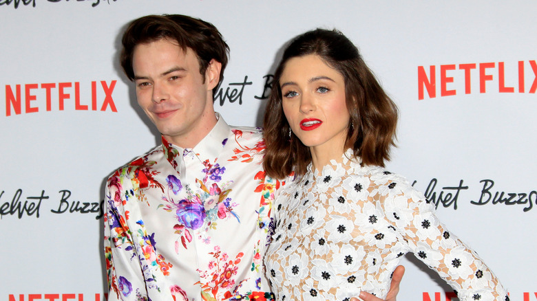 Charlie Heaton and Natalia Dyer posing in white printed shirts