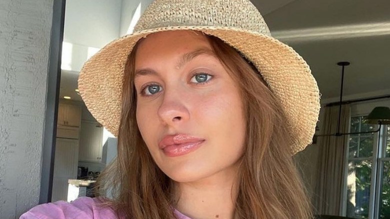 Natasha Bure poses for a selfie in a straw hat