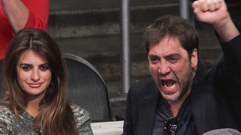 Penélope Cruz smiling, Javier Bardem with raised fist