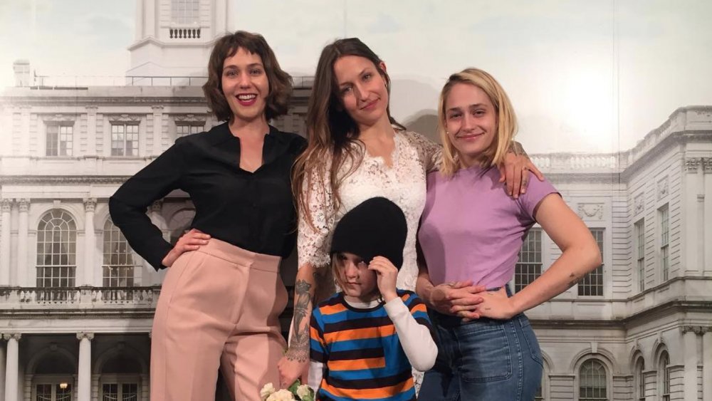 sisters Domino Kirke, Lola Kirke, and Jemima Kirke pose with Domino's son