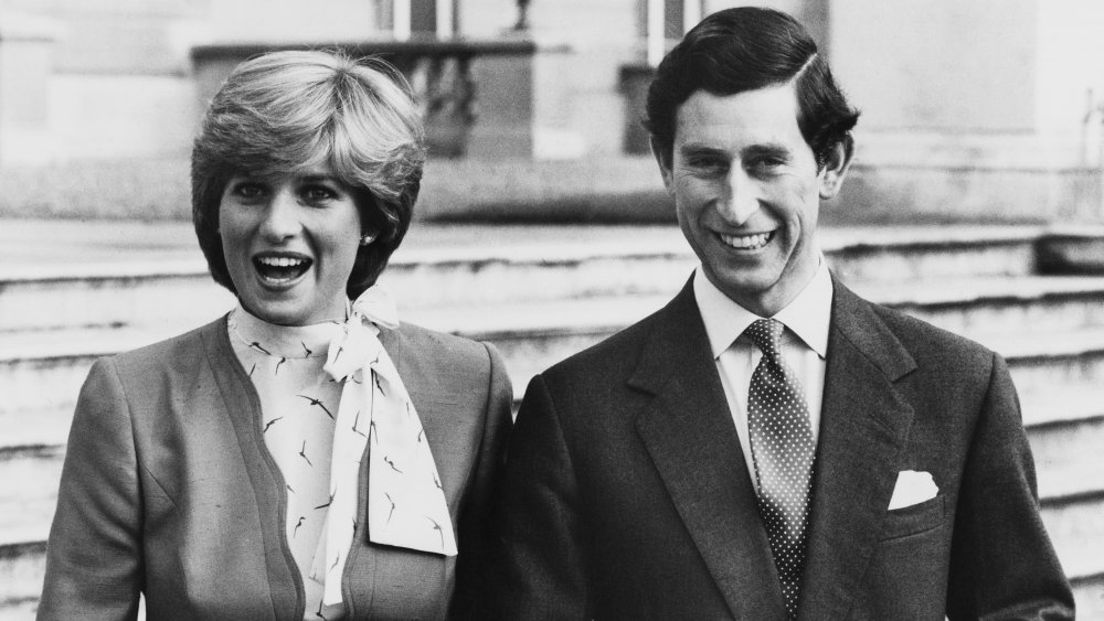 Black-and-white photo of Princess Diana and Prince Charles arm in arm and smiling