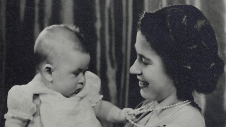 Queen Elizabeth II holding King Charles III as a baby