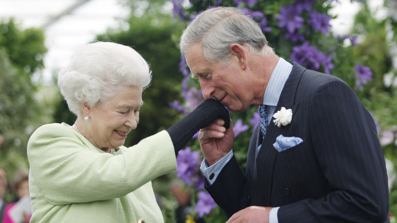 King Charles III kissing Queen Elizabeth's hand