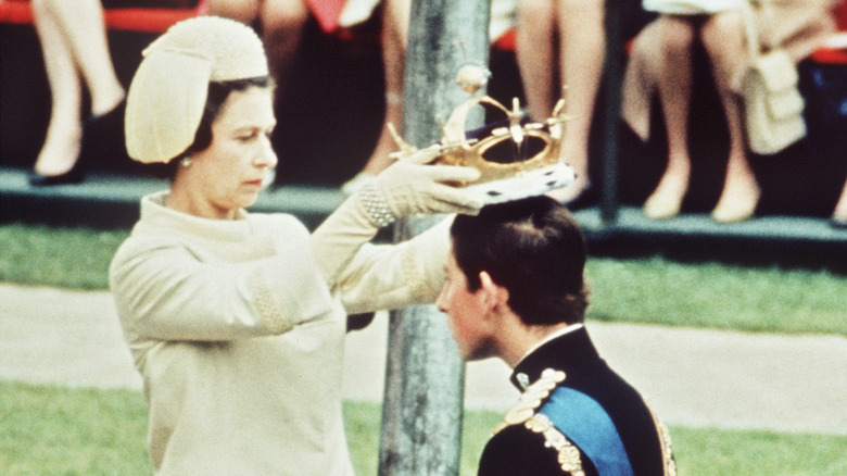 Queen Elizabeth II placing a crown on King Charles III's head