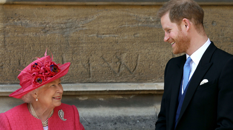 Queen Elizabeth and Prince Harry smiling at each other 