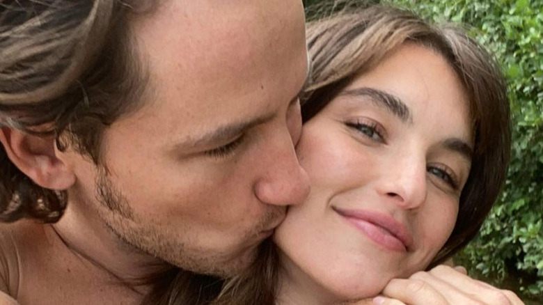 Lewis Pullman kisses Rainey Qualley on the cheek