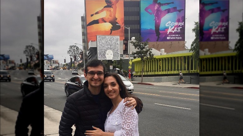 Daniel Macchio and Julia Macchio by a billboard