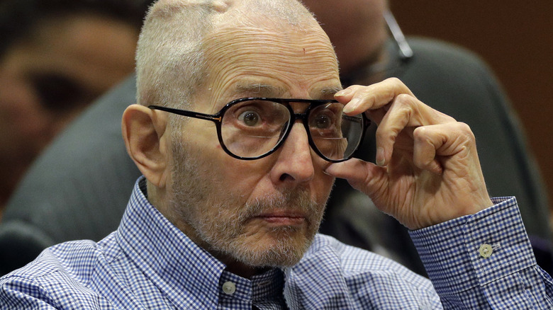 Robert Durst adjusting his glasses in 2016