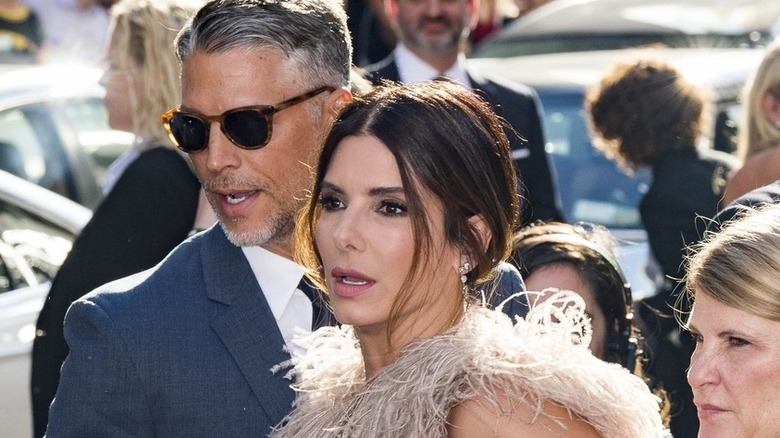 Sandra Bullock wearing feathers, Bryan Randall wearing sunglasses