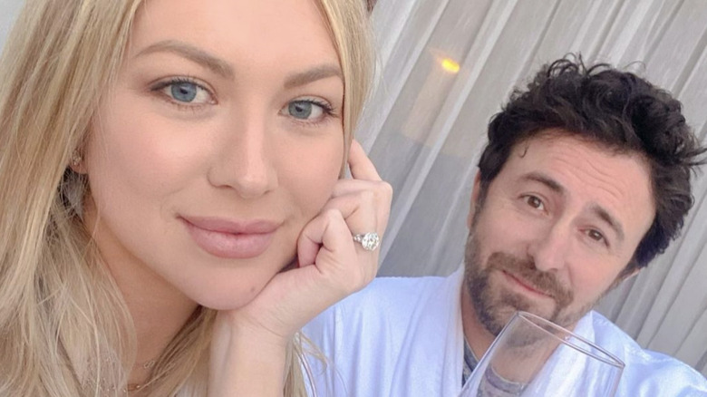 Stassi Schroeder with hand and engagement ring to face alongside Beau Clark