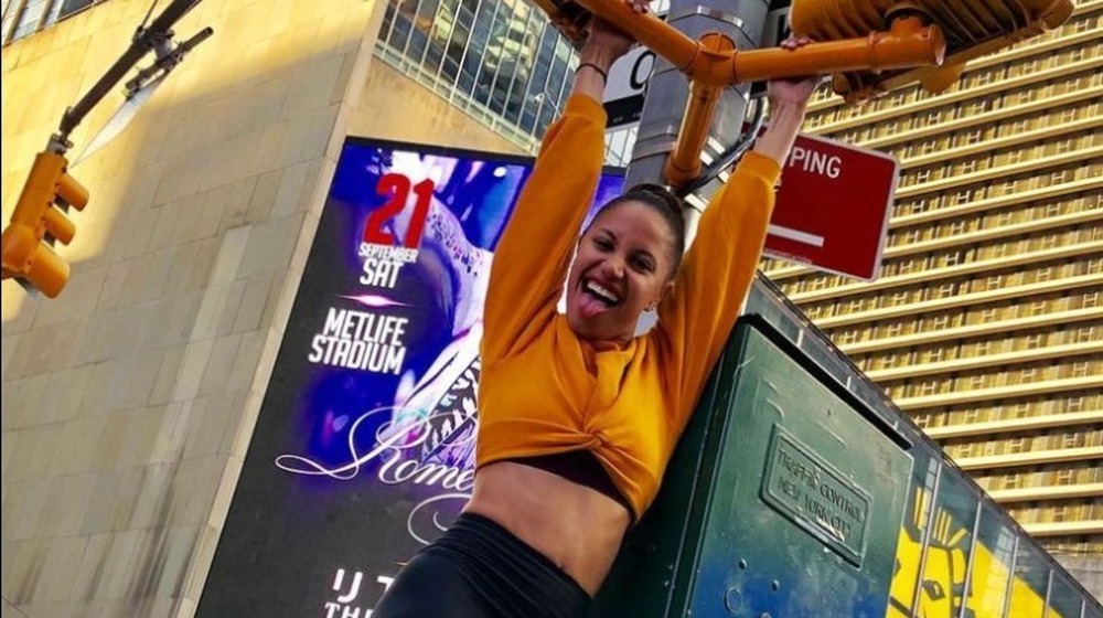 Ryan Claytor swings from a stoplight in New York City