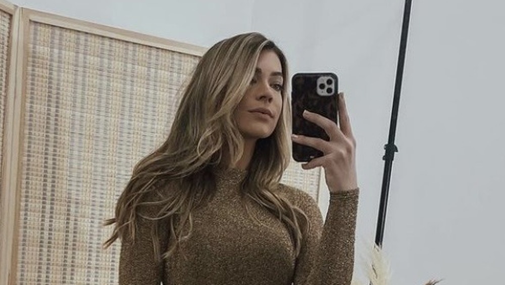 Sarah Trott, selfie in mirror, long-sleeve dress, smirking