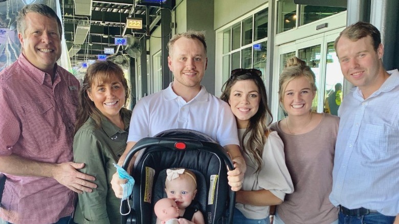 The Duggar family posing with car seat