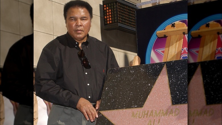 Muhammad Ali holding up his Walk of Fame star