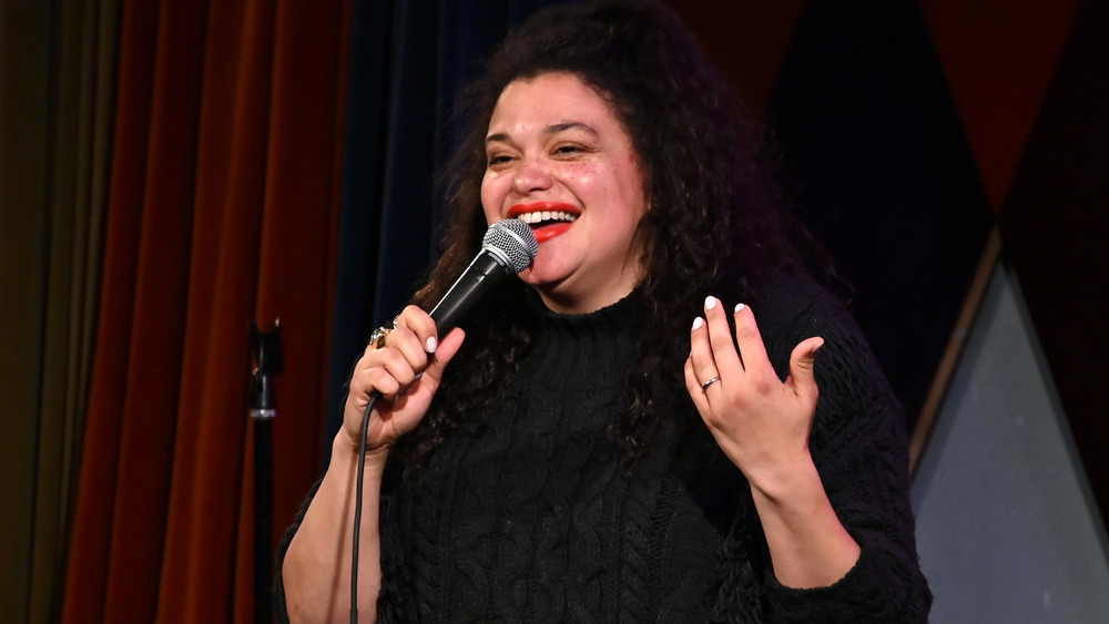 Michelle Buteau speaks on stage